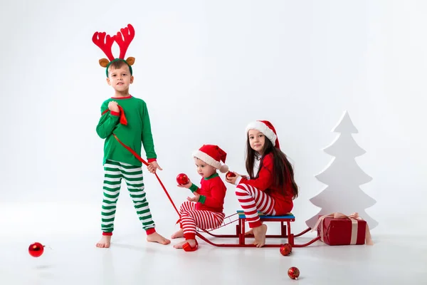 Brother Carrying Boy Girl Sitting Sleigh Festive Costumes — Stockfoto