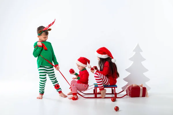 Brother Carrying Boy Girl Sitting Sleigh Festive Costumes — Stockfoto