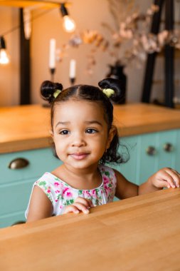 Küçük tatlı Afrikalı Amerikalı kız evde, mutfakta.