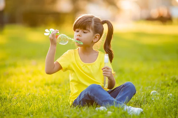 可爱的印度小女孩在夏天的草坪上吹肥皂泡 — 图库照片