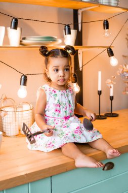 Küçük tatlı Afrikalı Amerikalı kız evde, mutfakta.