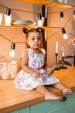 Küçük tatlı Afrikalı Amerikalı kız evde, mutfakta.