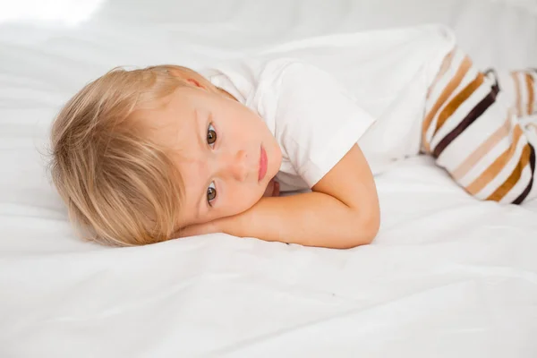 Уставший Маленький Мальчик Отдыхает Кровати Белыми Простынями — стоковое фото
