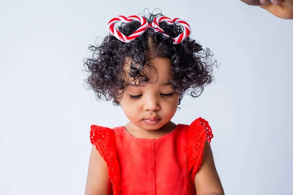 Cute little African American girl in summer clothes holding a baby windmill on a white background. the concept of summer holidays for children