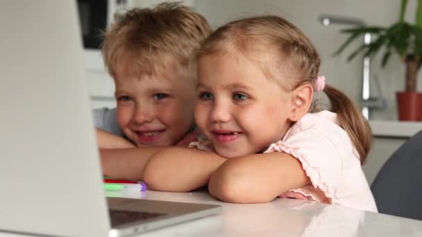 Two Young Children Boy Girl Sit Table Kitchen Watching Cartoons — Stock Video