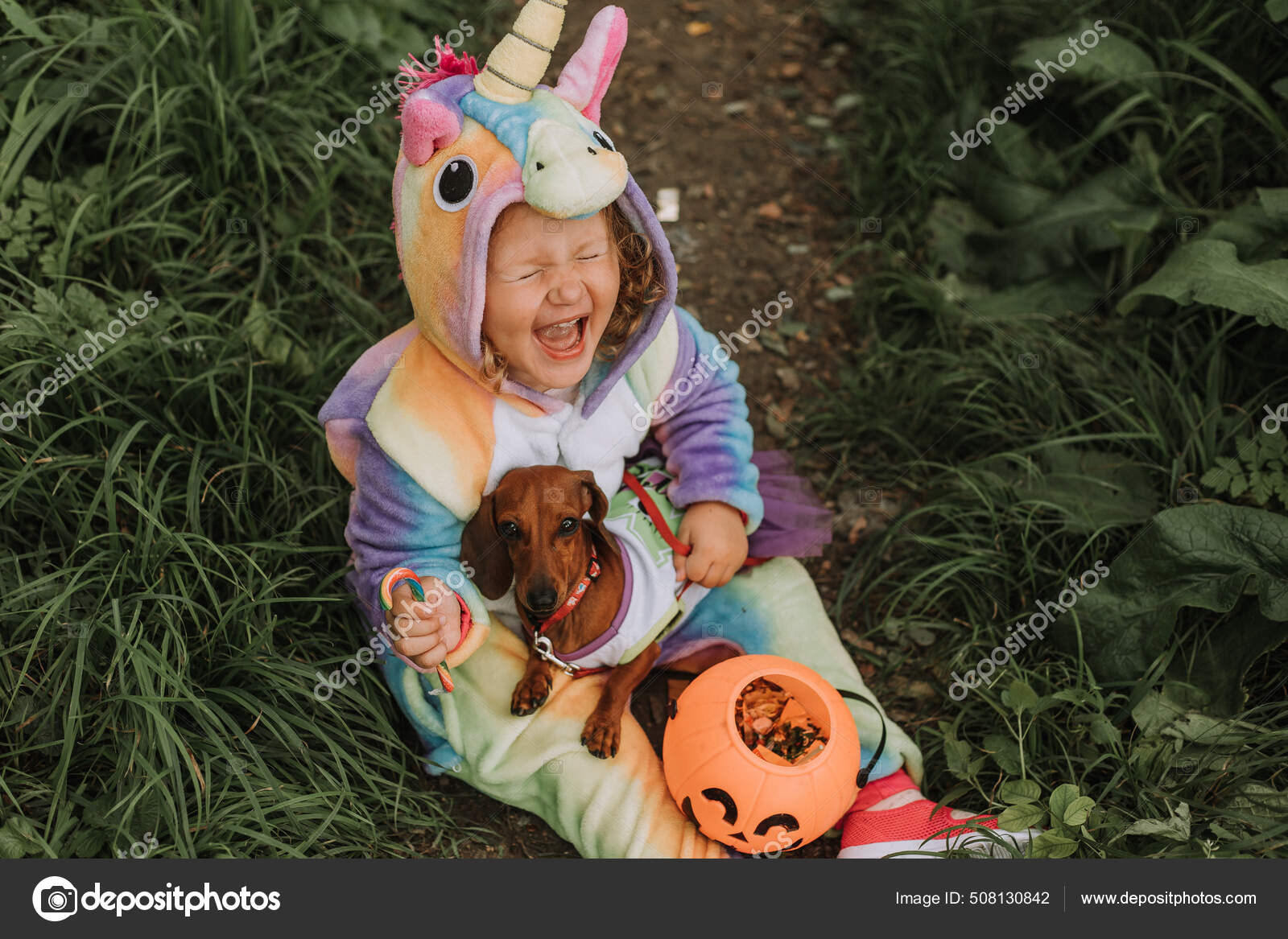 Jolie Petite Fille En Costume De Licorne Arc-en-ciel Pour Halloween Va  Chercher Des Bonbons Dans Un Panier De Citrouilles