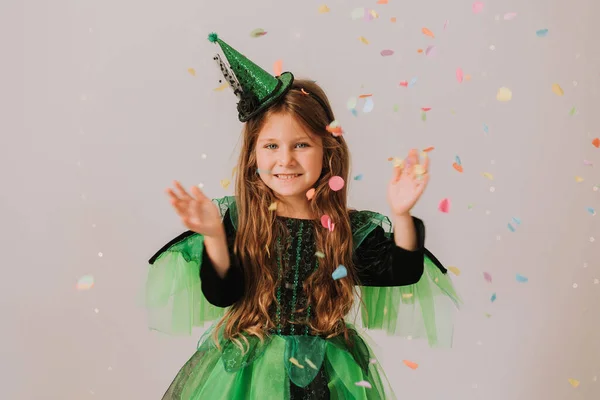 緑のカーニバルで美少女灰色のスタジオの背景にポーズ魔女のハロウィン衣装 トリックや治療 ハロウィンのコンセプト — ストック写真