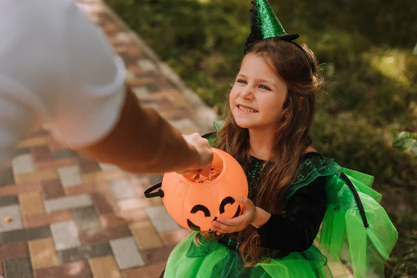 公園でカボチャのバスケットを保持ハロウィンの魔女の衣装でかわいい女の子 屋外で子供 トリックや治療 ハロウィンのコンセプト ストック写真