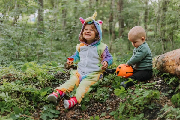 Mała Dziewczynka Tęczowym Stroju Jednorożca Kigurumi Siedzi Parku Młodszym Bratem Obrazy Stockowe bez tantiem