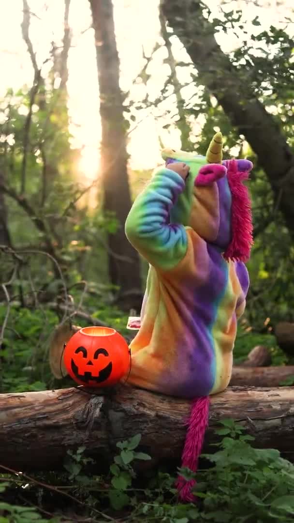 Little Girl Rainbow Unicorn Costume Kigurumi Sitting Tree Pumpkin Basket — Stock Video