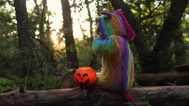 Kleines Mädchen Regenbogen Einhorn Kostüm Kigurumi Sitzt Auf Einem Baum — Stockvideo