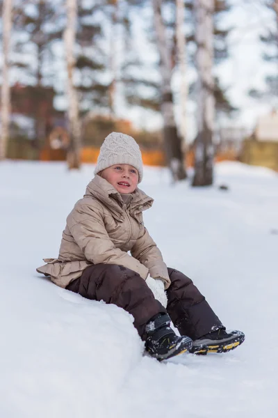 Winter girl sits in a snow snowbank — стоковое фото