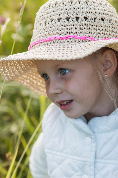 Sorrindo menina loira em um chapéu no dia ensolarado de verão no jardim — Fotografia de Stock