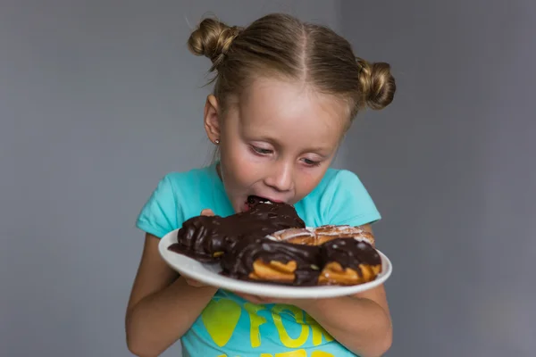 Девушка ест торт, который лежит на тарелке — стоковое фото
