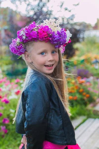 Portret van een vrolijk meisje met een krans van bloemen op haar hoofd — Stockfoto