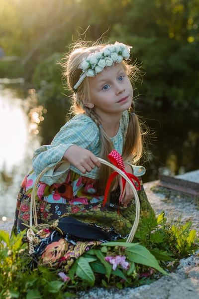 Russian girl in folk costume is walking on a summer evening in the woods with a basket — Stock Photo, Image