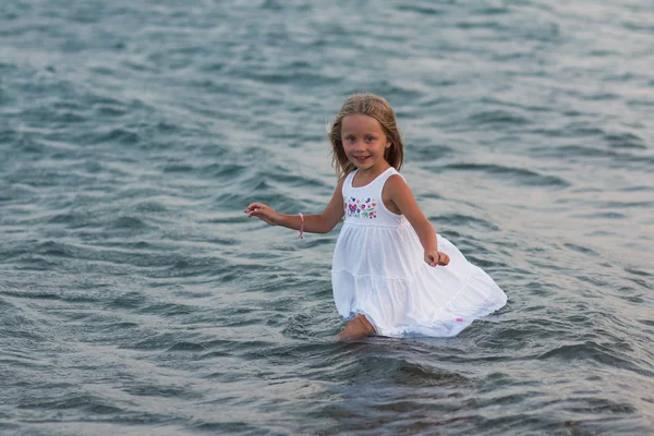Красивая девушка в платье, стоящее в морской воде — стоковое фото
