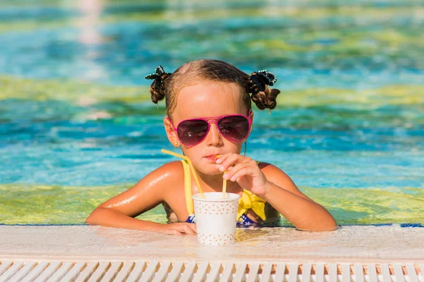 Szczęśliwa dziewczyna w okulary pić sok w basenie — Zdjęcie stockowe