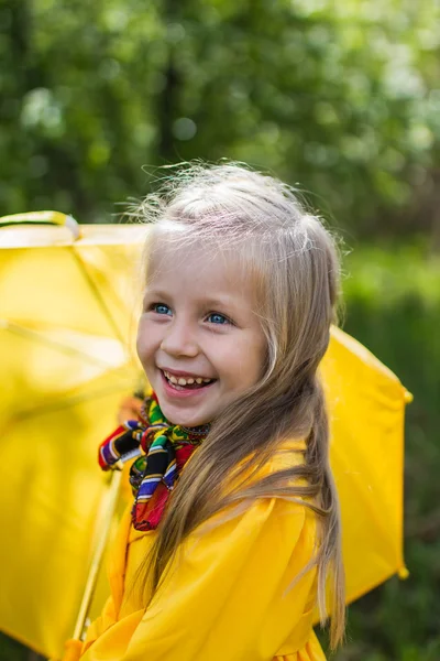 Retrato de niña alegre en un vestido amarillo con un paraguas amarillo — Foto de Stock