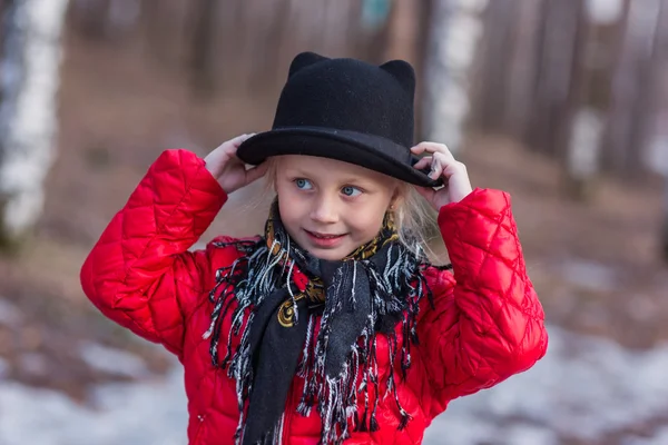 Mädchen mit schwarzem Hut mit Ohren und pavloposadskiye Schal geht im Park kalten Frühlingstag — Stockfoto
