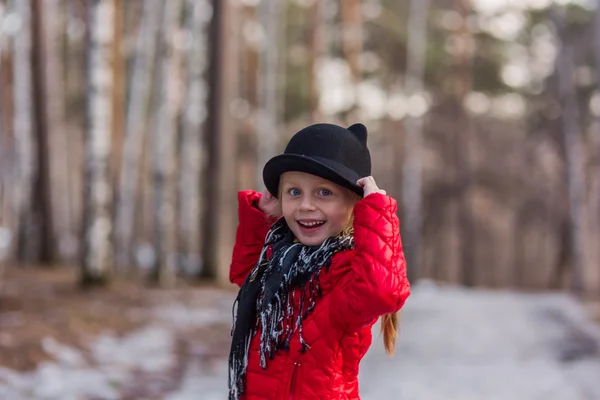 Mädchen mit schwarzem Hut mit Ohren und pavloposadskiye Schal geht im Park kalten Frühlingstag — Stockfoto