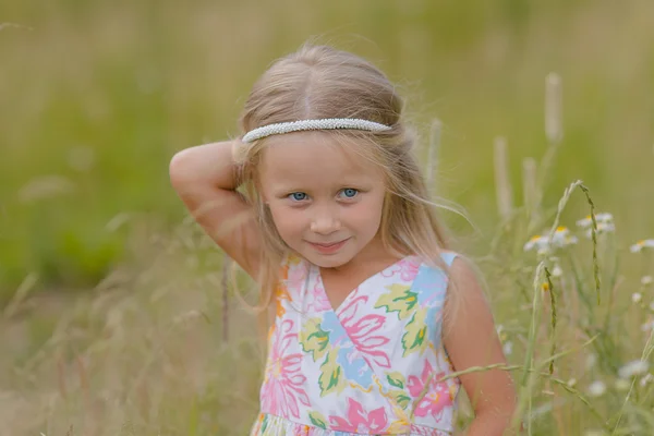 Flicka med långt hår gå längs fältet på en varm sommardag — Stockfoto