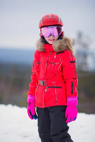 ヘルメット ゴーグル 明るいスーツでスキーとアクティブな愛らしい就学前の白人の女の子の肖像画は 冬の極端なスポーツ活動をお楽しみください 山に子供スキー — ストック写真