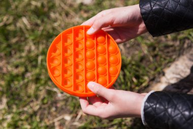 Renkli poppit oyunu olan çocuk. Renkli pop müziğiyle oynayan çocukların tavşan resimlerini yakın çekim. Stres önleyici oyuncak