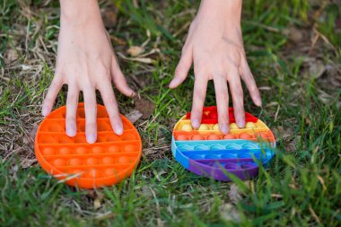 Renkli poppit oyunu olan çocuk. Renkli pop müziğiyle oynayan çocukların tavşan resimlerini yakın çekim. Stres önleyici oyuncak