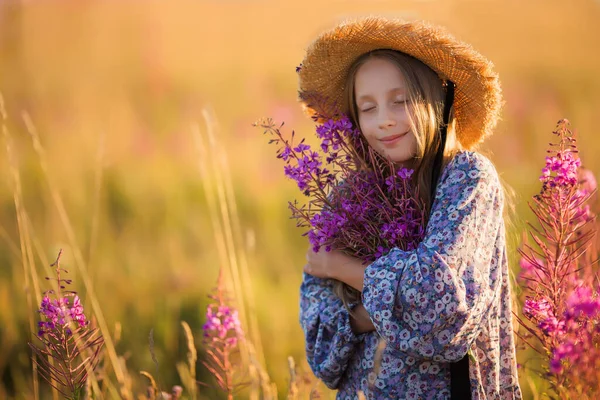 花束のある帽子の子供 花束を持った女の子が花の牧草地に立っている 夏時間 — ストック写真