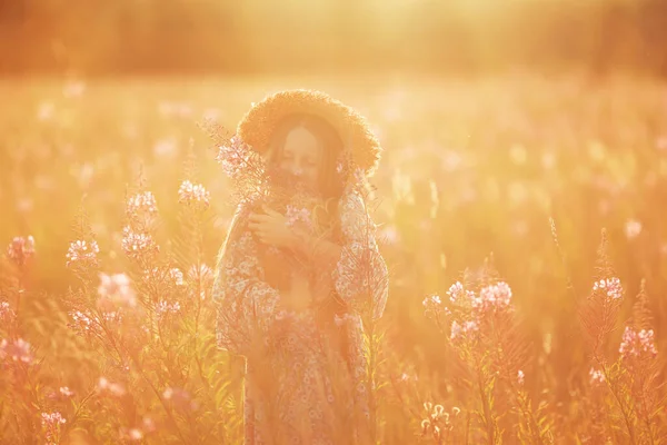 花束のある帽子の子供 花束を持った女の子が花の牧草地に立っている 夏時間 — ストック写真