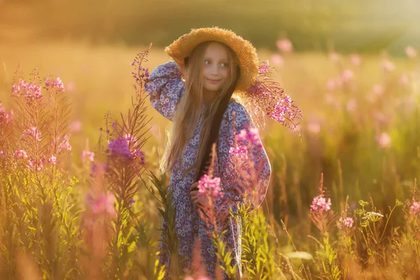 花束のある帽子の子供 花束を持った女の子が花の牧草地に立っている 夏時間 — ストック写真