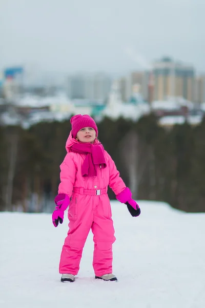Glückliches kleines Mädchen, das durch die verschneiten Berge läuft — Stockfoto
