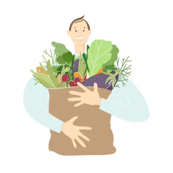 Un joven sonriente sostiene un paquete grande con verduras y hierbas en sus manos. Alimento saludable —  Fotos de Stock