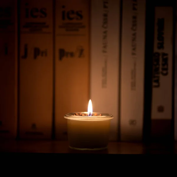Soy candle lights old book in the library