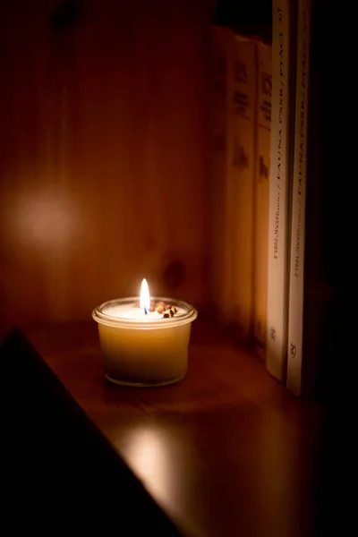 Soy candle lights old book in the library — Stock Photo, Image