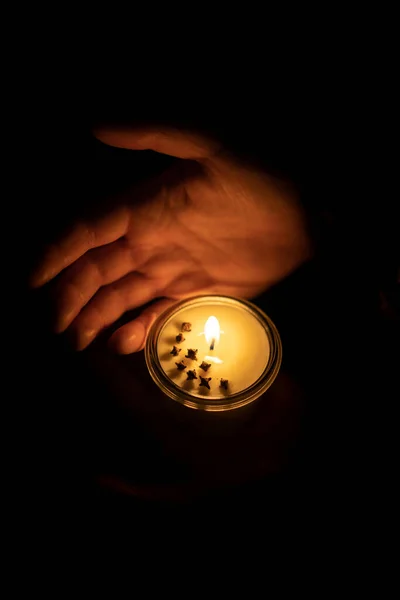 Vela de soja e mãos pequenas ao redor — Fotografia de Stock