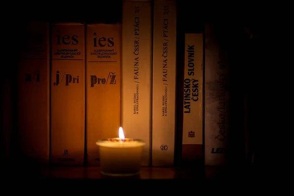 Soy candle lights old book in the library — Stock Photo, Image