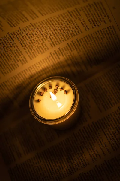 Soya mumu kütüphanedeki eski kitabı yakıyor.