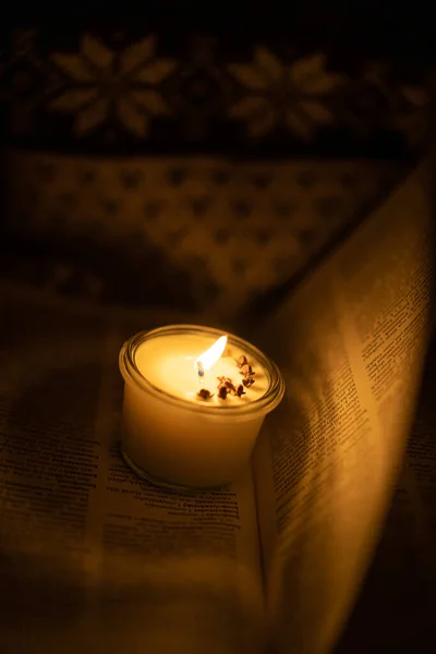 Soy candle lights old book in the library