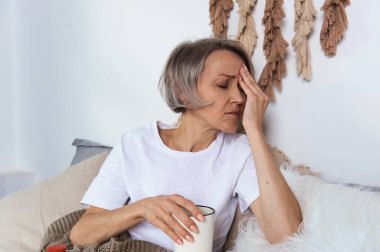 Yatakta ilaç alan orta yaşlı bir kadın