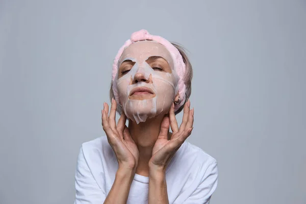 Kadın yüzüne maske takıyor.