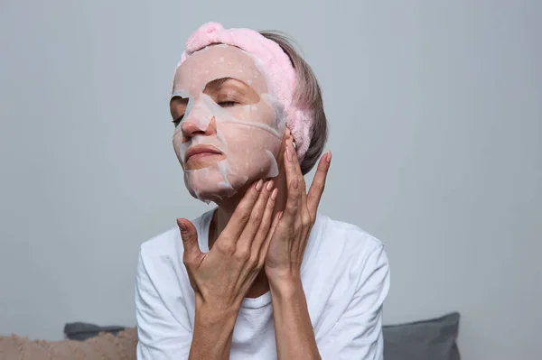 Kadın yüzüne maske takıyor.