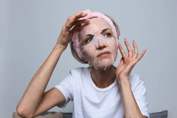 Kadın yüzüne maske takıyor.