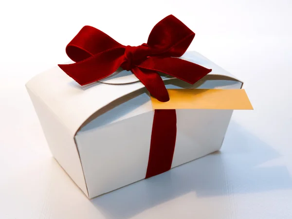 Boîte cadeau vintage enveloppée avec ruban rouge noeud sur fond clair — Photo
