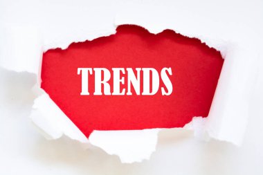 Yeşil yırtık kağıt altında yazılan trend kelimesi