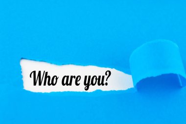 Kimsiniz siz? Yırtık kağıt altında yazılmış soru.