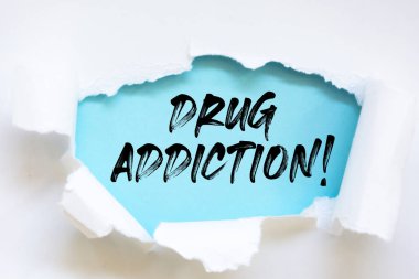 Yırtık kağıdın altında yazan Uyuşturucu Bağımlılığı.