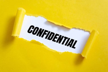 Beyaz yüzeyde yırtık sarı kağıt ve gizli kelimeler..