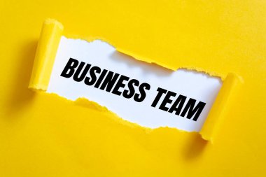 Yırtık sarı kağıdın arkasında görünen BÜYÜK Ekibi